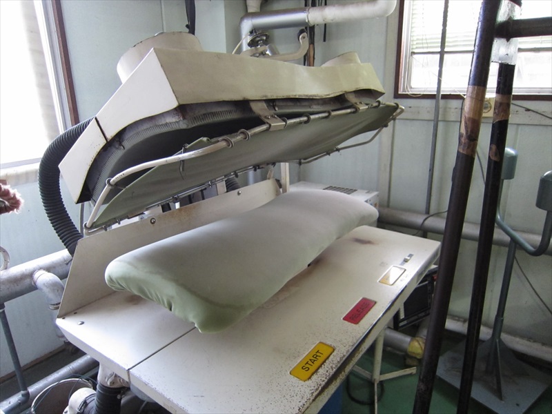 ブレザーの背中の全体をプレスする機械の写真